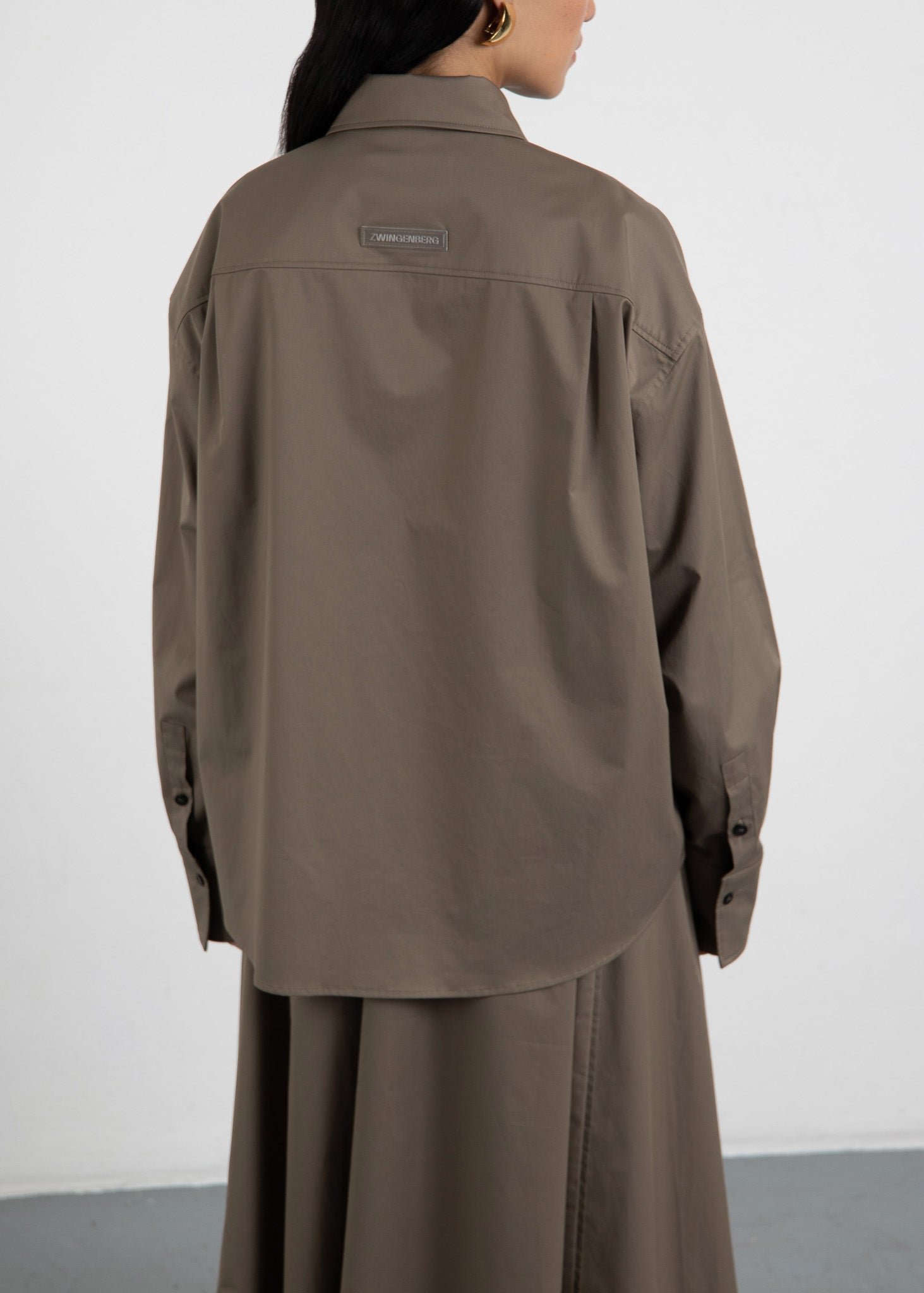 Rückenansicht des oversized Hemds The Shirt 3 in Olive von Zwingenberg, mit Rückenpasse und aufgestepptem Logo Tag