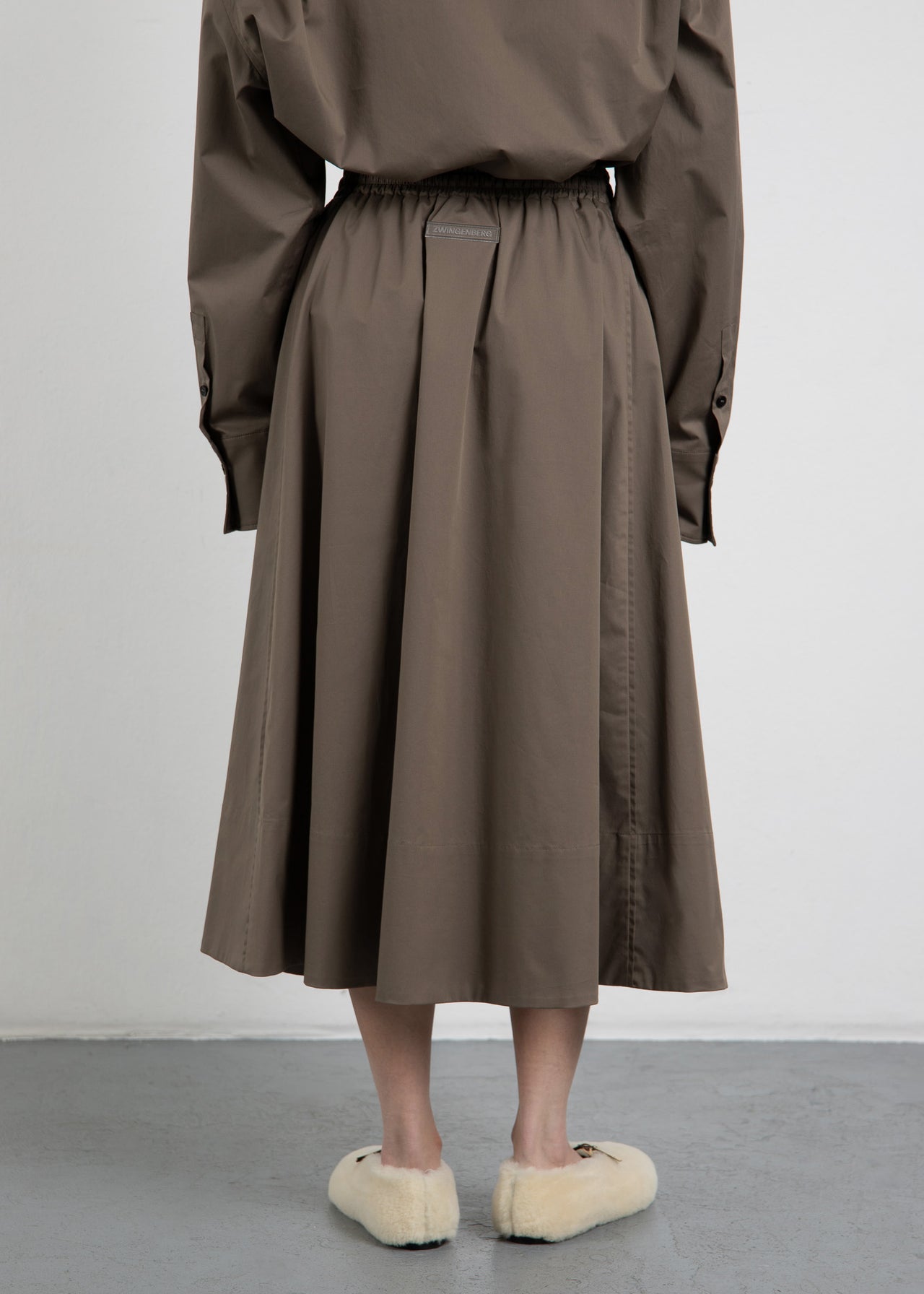 Rückansicht des A-Linien-Rock The Skirt 2 in Olive von Zwingenberg, mit eleganten Paspeldetails, transparenten Zwingenberg-Patch in der hinteren Mitte