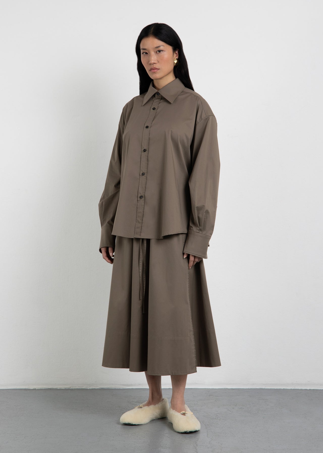 A-Linien-Rock The Skirt 2 Olive von Zwingenberg mit Paspeldetail, eleganten Frontschlitzen und transparentem, recyceltem Zwingenberg-Patch.