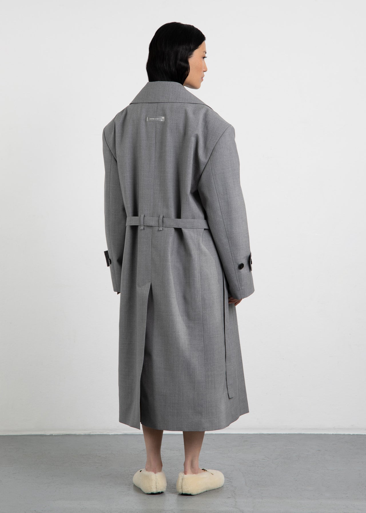 Zwingenberg Trenchcoat The Trench 1 in Grau Melange, mit transparentem, nachhaltigem Logo-Tag auf der Rückseite in der Mitte aufgesteppt