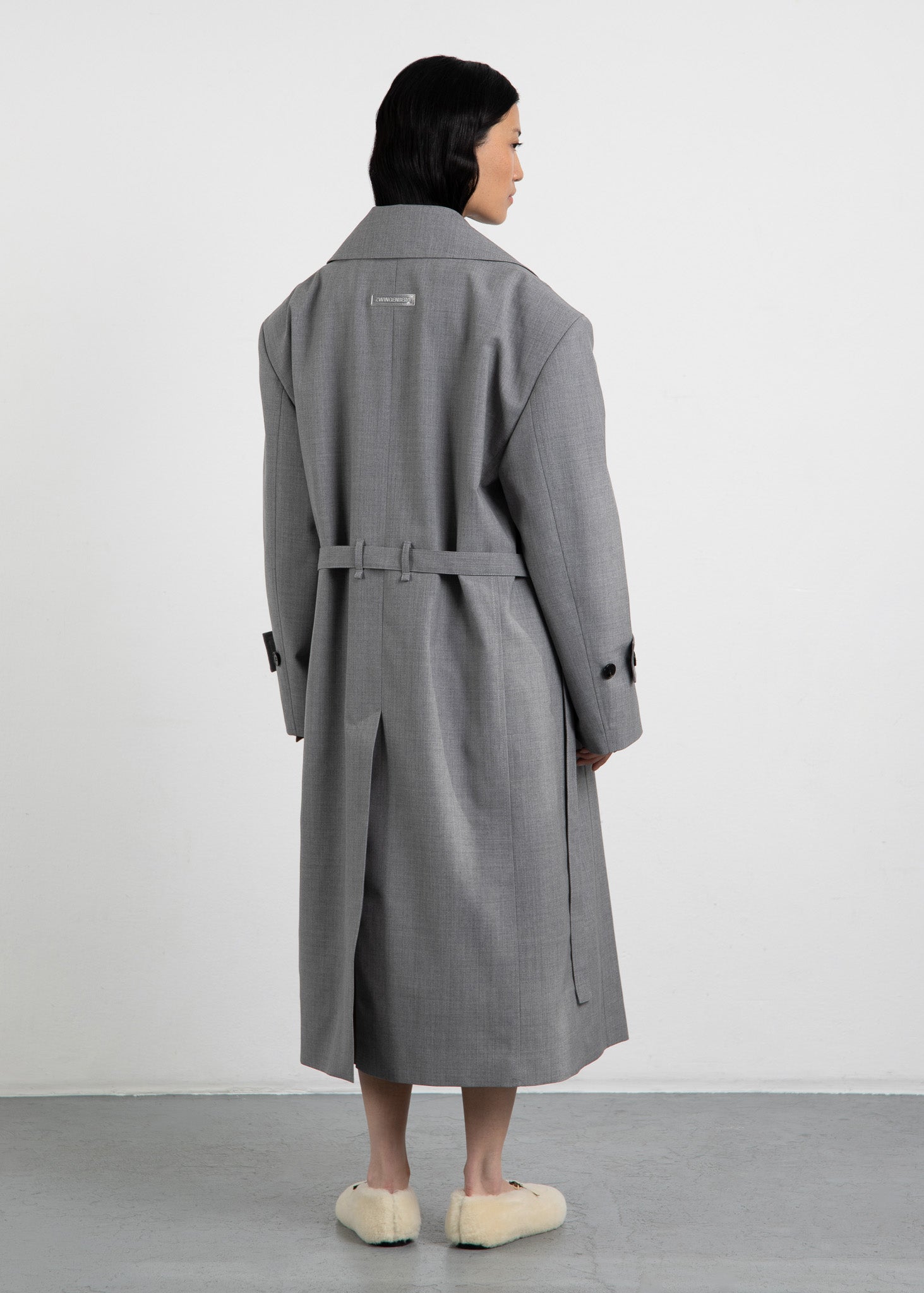 Zwingenberg Trenchcoat The Trench 1 in Grau Melange, mit transparentem, nachhaltigem Logo-Tag auf der Rückseite in der Mitte aufgesteppt