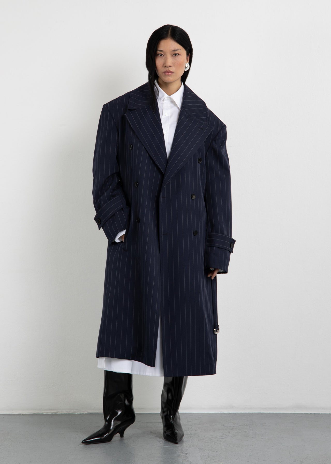 Unisex Trenchcoat The Trench 1 in Navy Nadelstreifen von Zwingenberg in Oversized-Passform mit Schulterpolstern, recyceltem transparentem Zwingenberg-Patch, Logo-Knöpfen.